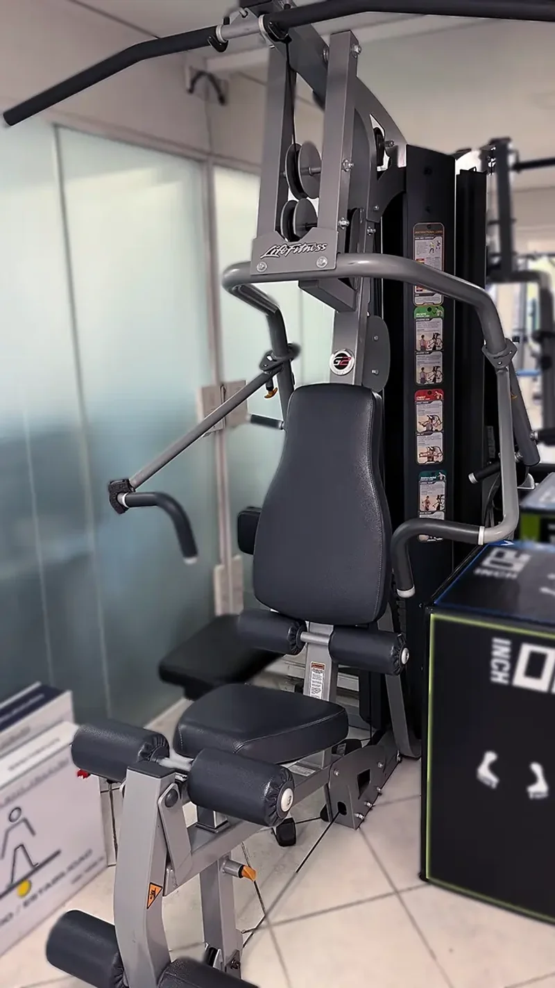 Imagen de estación de entrenamiento versátil con torre de pesas en centro de kinesiología KinesicWork, usada en rehabilitación integral